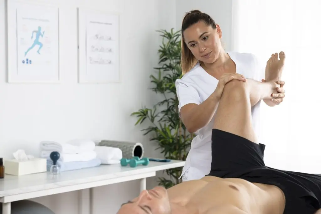 female physiotherapist massaging male patient office